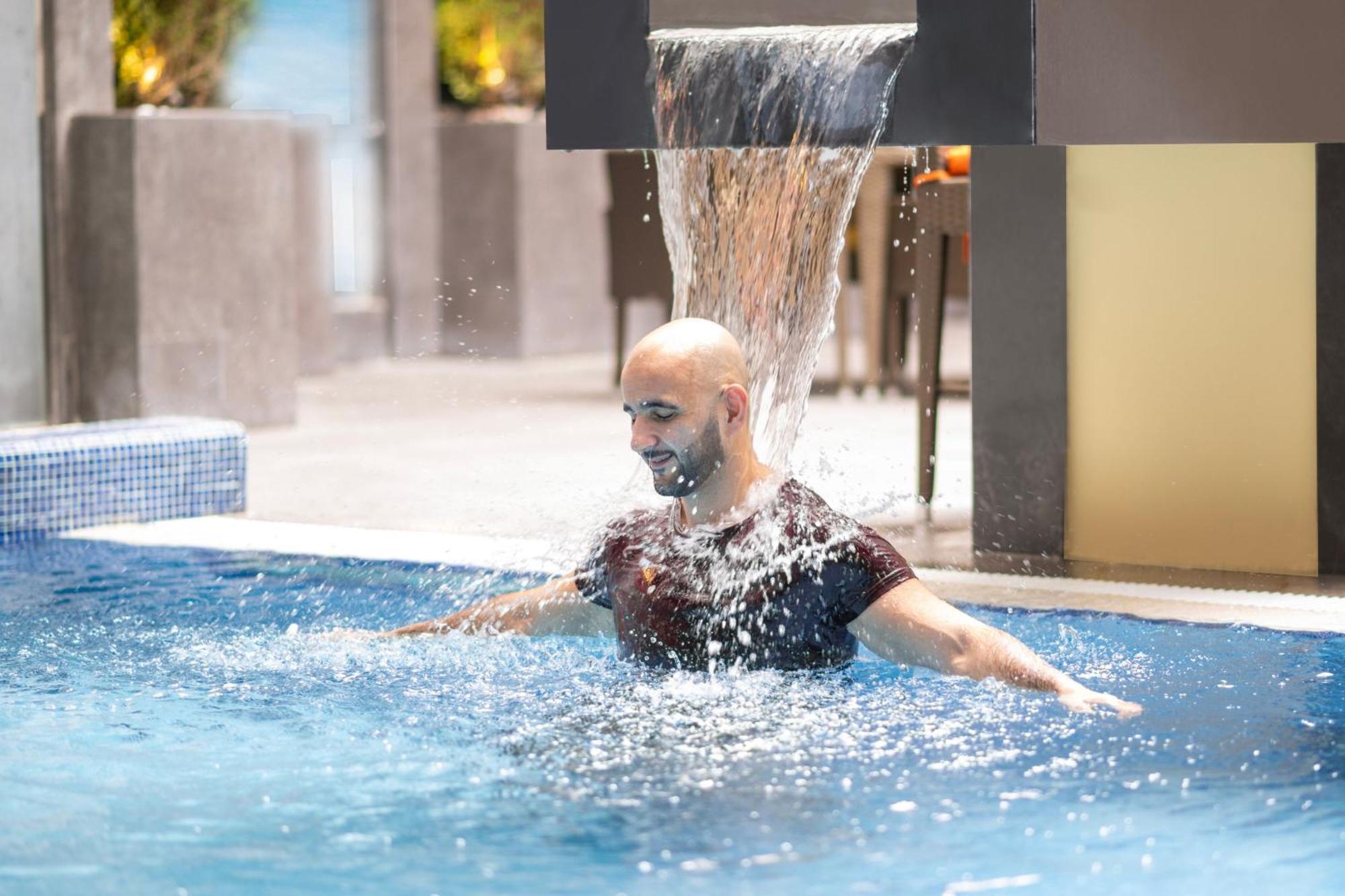 Delta Hotels By Marriott City Center Доха Экстерьер фото A man swimming in a pool
