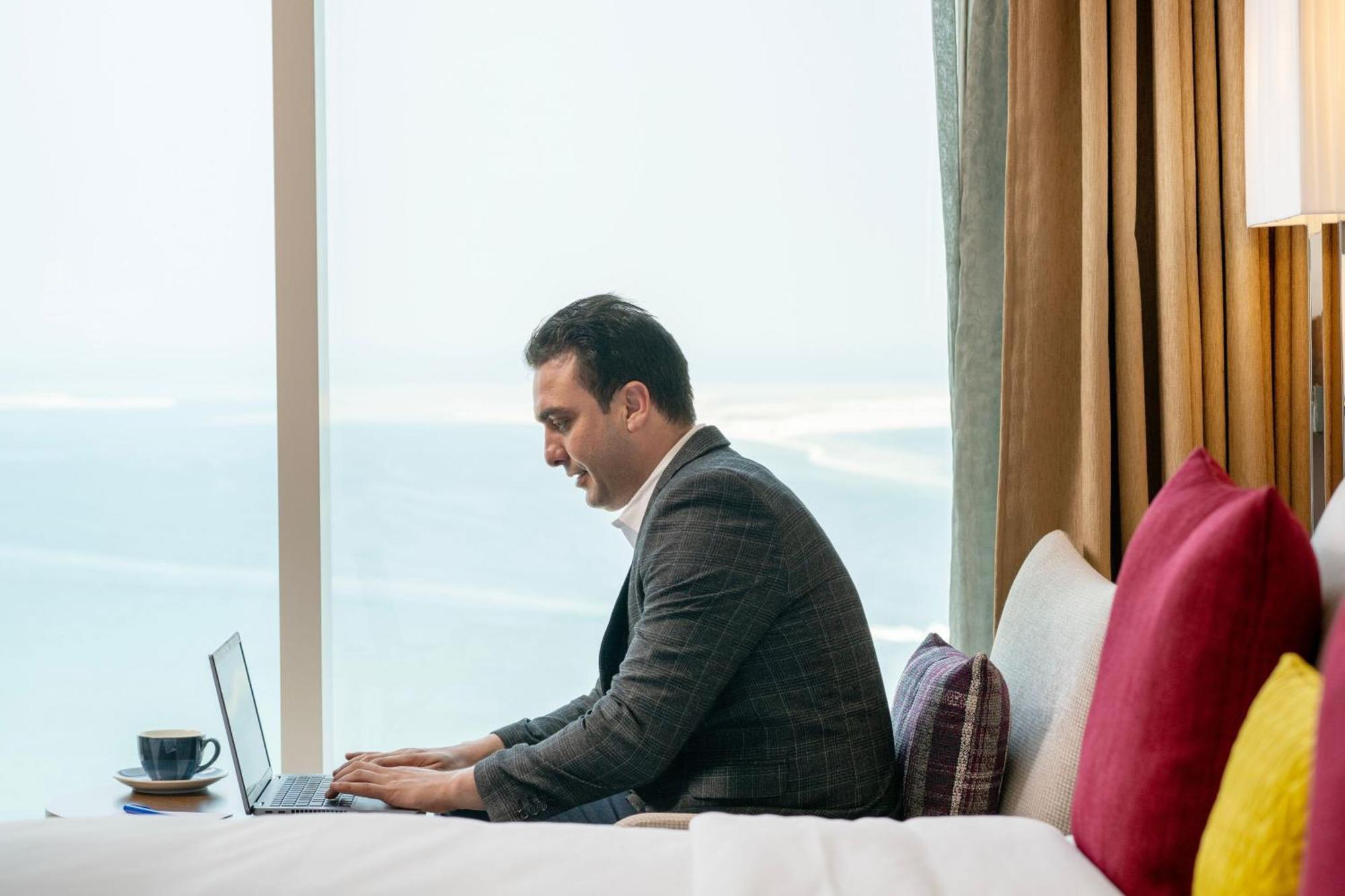 Delta Hotels By Marriott City Center Доха Экстерьер фото A businessman working on a laptop